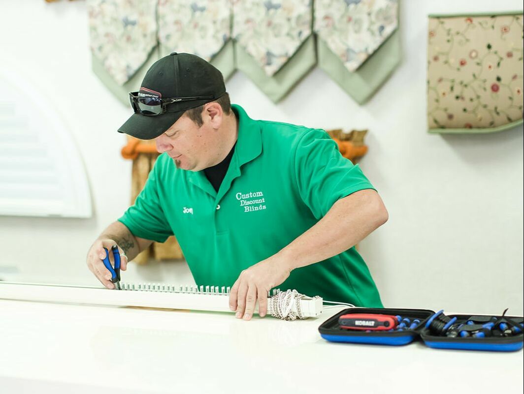 Joey Calello, owner at Custom Discount Blinds in Spring Hill, repairs a broken blind.